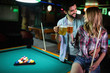 © NDABCREATIVITY - Happy young man playing snooker with his girlfriend. Happy loving couple.