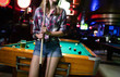 © NDABCREATIVITY - Young smiling girl playing billiard in club