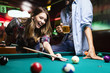 © NDABCREATIVITY - Happy young man playing snooker with his girlfriend. Happy loving couple.