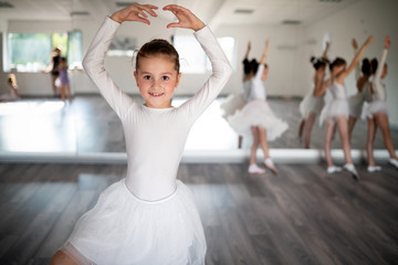 Wall Mural - Group of fit happy children exercising ballet in studio together