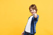 © ViDi Studio - Fun cheerful happy little kid boy in blue shirt white t-shirt posing gesturing hands isolated on yellow wall background children studio portrait. People childhood lifestyle concept. Mock up copy space