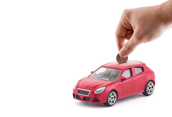 Poster - Putting coin into the car coin bank on white background 