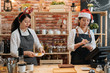 © PR Image Factory - two asian female bartenders dressed in santa hat and working in bar counter in christmas holidays. woman barista prepare croissant while coworker waitress taking note on customer order in xmas.