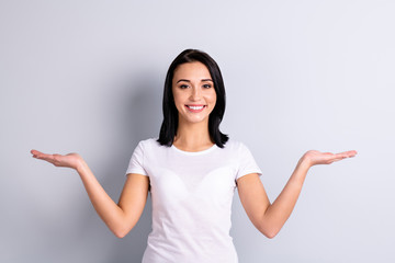 Wall Mural - Portrait of her she nice-looking attractive lovely cheerful cheery confident girl holding two objects on palms copy empty blank space ad advert isolated over light gray pastel background