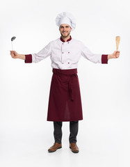 Wall Mural - Positive toothy chef cook in beret, white outfit having tools in crossed arms looking at camera isolated on white background.