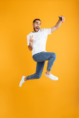 Sticker - Full length photo of happy caucasian man having beard taking selfie on cellphone and showing peace sign