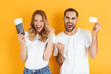 Sticker - Image of delighted couple rejoicing while holding credit card and passport with travel tickets