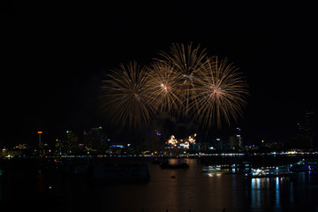 gold thin fireworks on beach and reflection color on water surface