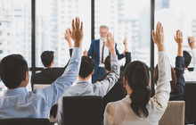 Group Of Business People Raise Hands Up To Ask Question And Answer To Speaker In The Meeting Room Seminar