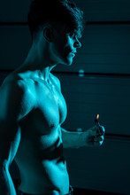 Sexy Shirtless Muscular Man Holding Lighter In Darkness