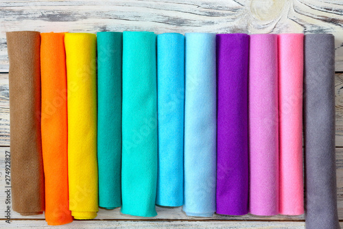 Rolls of bright colored felt fabric on a white wooden background Fototapete