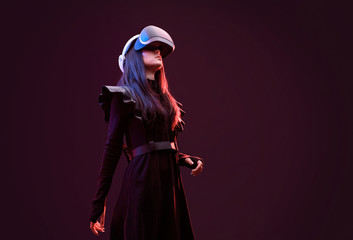 Wall Mural - beautiful woman in futuristic dress over dark background. girl in glasses of virtual reality. augmen