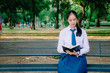 © TeTe Song - A shot of a girl college student sitting reading book on a bench in the park