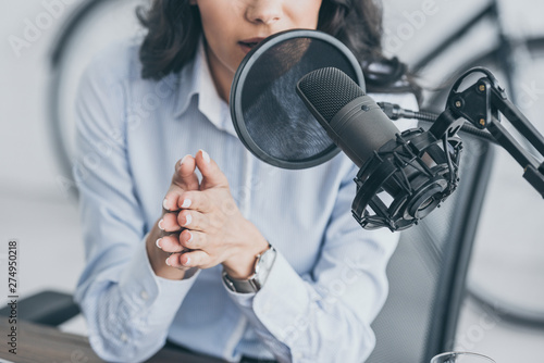 Fotomural cropped shot of radio host speaking in microphone in broadcasitng studio