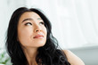 © LIGHTFIELD STUDIOS - low angle view of pensive and attractive thai woman