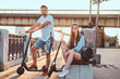 © Fxquadro - Young attractive couple are relaxing at riverside with their electro scooters. There are bright sunny day.