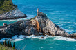 Church of Saint Peter (Chiesa di San Pietro) built on rugged sheer cliffs surrounded by the turquoise water of the Gulf of Poets in Porto Venere, La Spezia, Italy, as seen from above.