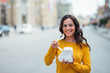 © bnenin - Happy young woman with takeout food in urban background.