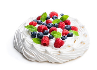 Pavlova meringue nest with berries and mint leaves isolated on white