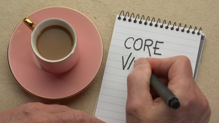 Canvas Print - core values - man hand writing a note with a black marker in a spiral notebook, overhead view