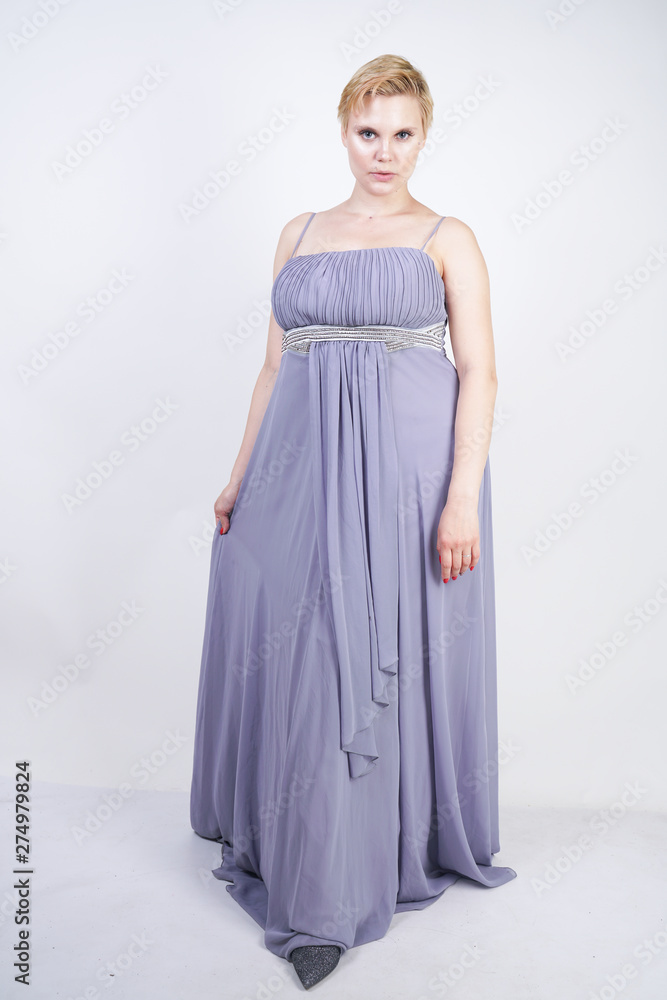 elegant thick female in a grey long dress. pretty plus size woman in  evening dress standing on white studio background. short hair chubby girl  in gray clothes posing alone. Stock Photo |