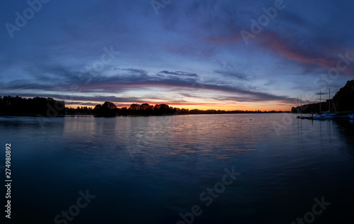 Piękny zachód słońca nad jeziorem Kalwa na Mazurach w Polsce.