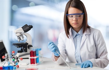 Wall Mural - Female and male scientists in glasses working with microscope