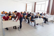 © as-artmedia - Male professor explain lesson to students and interact with them in the classroom.Helping a students during class.