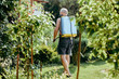 © Sebastian - The man sprays plants protecting them from pests. The man has a manual sprayer with pesticides on his back. The concept of taking care of the garden, healthy plants and beautiful flowers.