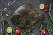 Raw whole flounder fish with rosemary, onions and spices on dark stone background. Creative layout made of fish, top view