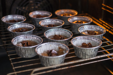 Wall Mural - Raw muffins in the forms in the oven. Cooking chocolate muffins.