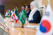 © pressmaster - Green flag of muslim country and tricolor one on long table