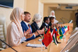 © pressmaster - Young female delegate in hijab and her foreign colleagues applauding