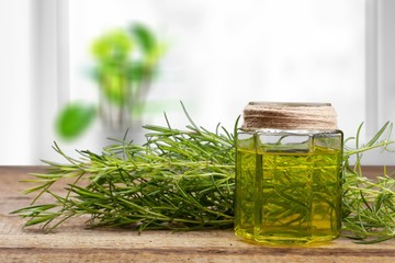 Wall Mural - Oil bottle and green herbs on blue background