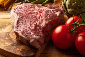 Wall Mural - Juicy fresh piece of marbled beef steak with vegetables for grilling. Culinary background, recipe book, delicious food, Steak cooking. Close-up. macro