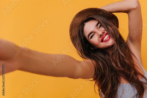 Fotomural Tanned lady with blissful face expression making selfie and laughing