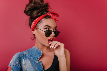 Wall Mural - Surprised pretty woman with cute manicure looking away with mouth open. Close-up portrait of beautiful girl with vintage hairstyle wears black sunglasses.