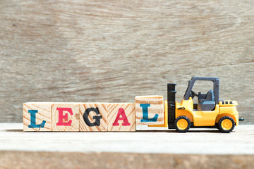 Sticker - Toy forklift hold letter block l to complete word legal on wood background