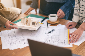 Wall Mural - Group of an architect working and measuring scale of a mass model on table in office