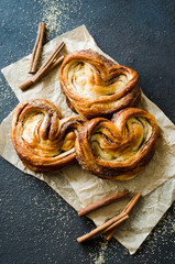 Wall Mural - Baked fresh fragrant cinnamon buns. Traditional homemade pastries on dark background..