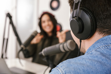 Wall Mural - Man and woman in white shirts podcasters interview