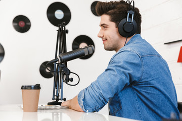 Wall Mural - Handsome happy young male radio host broadcasting