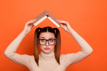 Wall Mural - Close up photo beautiful amazing she her lady pretty hairdo hold arms hands favorite novel above head bad mood sorry guilty expression wear casual pastel pullover clothes isolated orange background