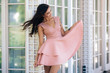 © romannoru - Attractive girl with beautiful smile in pink dress posing in street cafe