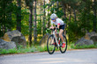 © Maksym Protsenko - Young Woman Cyclist Riding Road Bicycle on the Free Road in the Forest at Hot Summer Day. Healthy Lifestyle Concept.