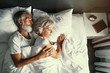 © luengo_ua - Senior family couple sleeping together in bed.