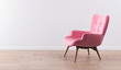 Fashionable modern pink armchair with wooden legs against a white wall in the interior. Furniture, interior object, modern designer armchair. Stylish minimalist interior