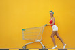 © luengo_ua - Big summer sale! Young smiling woman posing next to an empty shopping yellow wall.