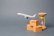 © Andrii Yalanskyi - Airplane takes off behind the stack of cardboard boxes and a sand clock. concept of air cargo and parcels, airmail. Fast delivery of goods and products. Cargo aircraft. Logistics, connection