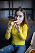 © leberus - Funny brunette girl in yellow sweater eating pizza at home